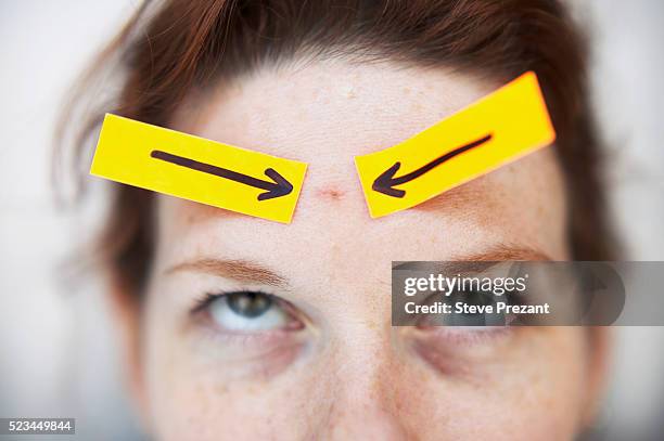 arrows pointing to blemish on woman's forehead - acnes stockfoto's en -beelden