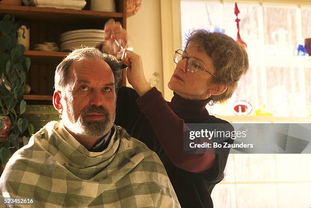 woman cutting husband's hair in kitchen - bo zaunders stock pictures, royalty-free photos & images