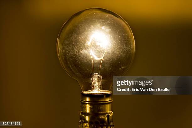 an antique lightbulb shining bright - eric van den brulle stock-fotos und bilder