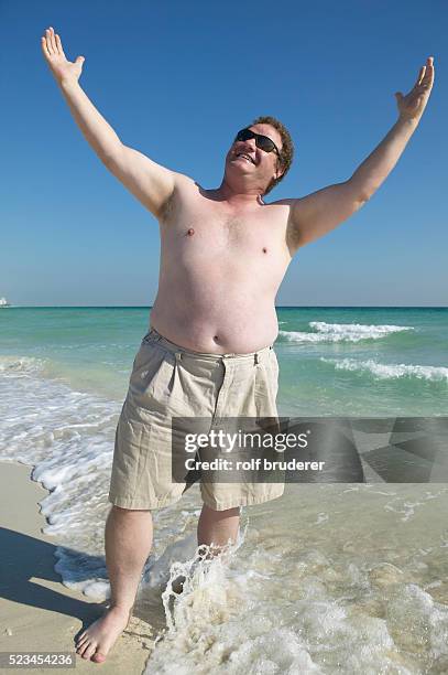 man relaxing at beach - fat man on beach stockfoto's en -beelden