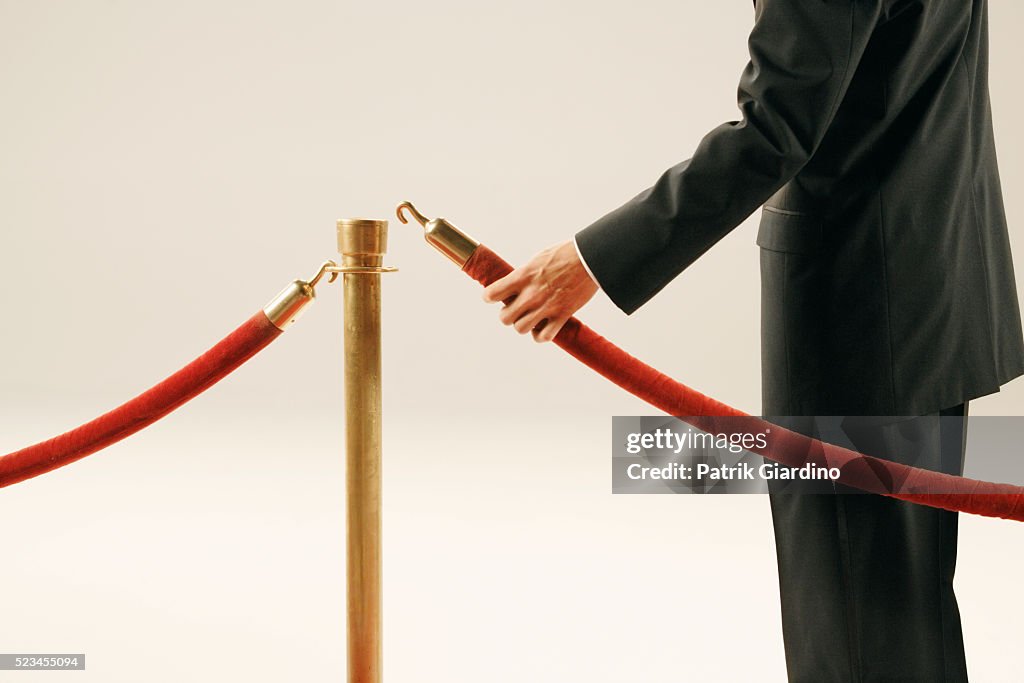 Man Holding Velvet Rope