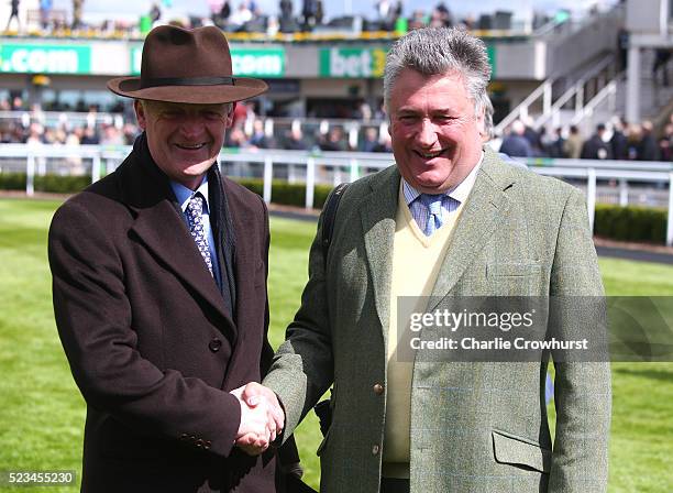 Trainer's Willie Mullins and Paul Nicholls share a joke as they pose for a photo in the parade ring ahead of the first race at Sandown racecourse on...