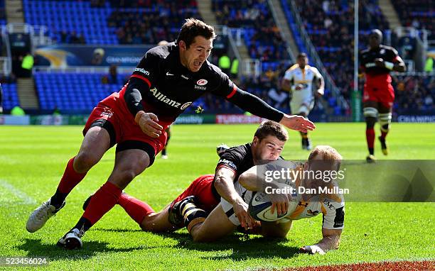 Dan Robson of Wasps dives over for his side's first try under pressure from Richard Wigglesworth of Saracens and Alex Goode of Saracens during the...