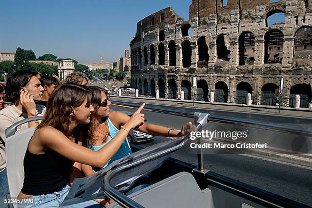 young tourists passing the colosseum - ônibus de turismo - fotografias e filmes do acervo