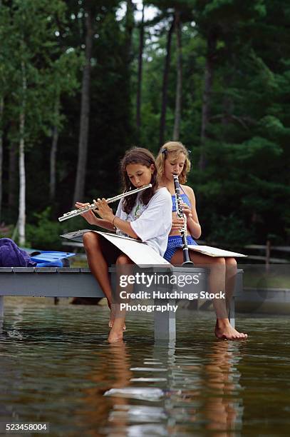 two girls playing musical instruments - flauto foto e immagini stock
