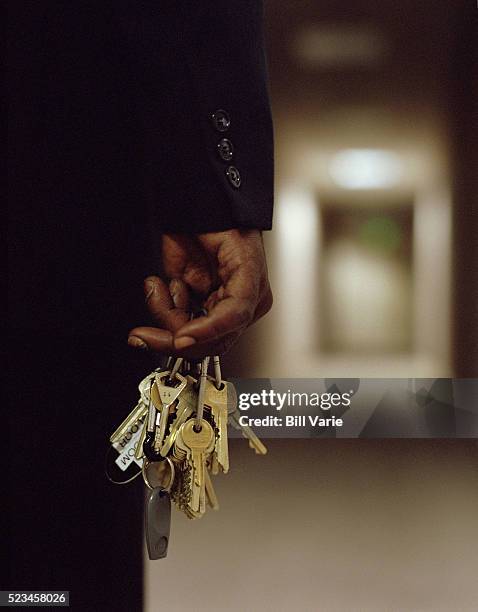 security guard holding keys - trousseau de clés photos et images de collection