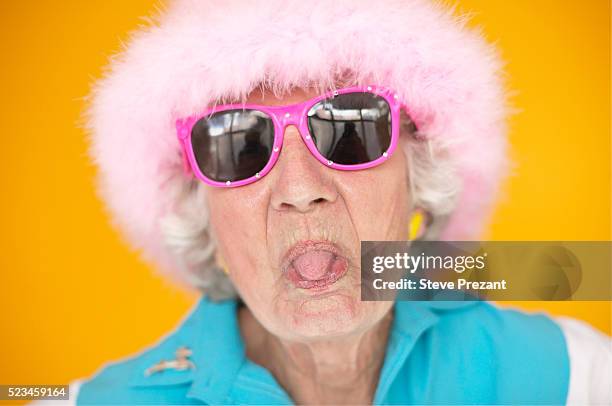 playful senior woman sticking out her tongue - pouting stock pictures, royalty-free photos & images