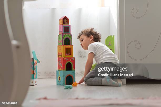 a little boy playing with cubes - pyramid shapes around the house stock-fotos und bilder