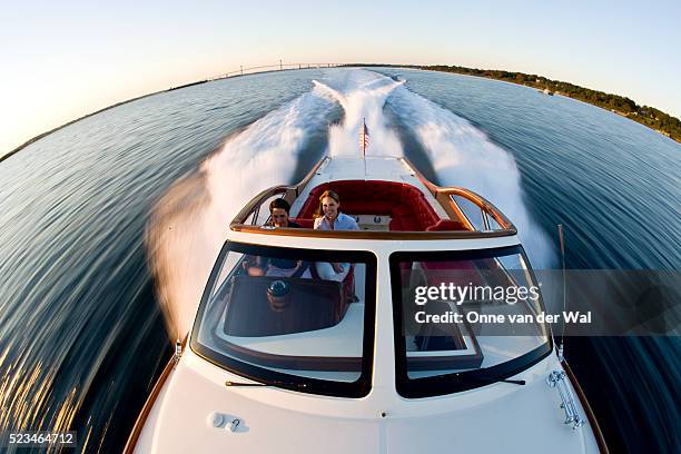 couple in hinckley talaria 38 powerboat on narragansett bay - speed boat stock pictures, royalty-free photos & images