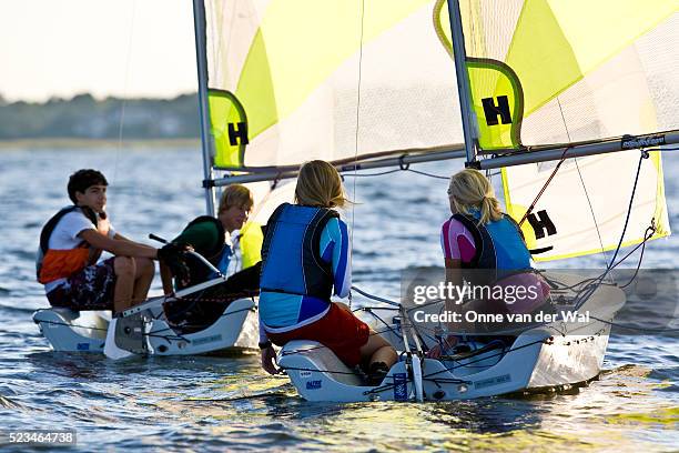 teenagers racing matching rs feva sailboats at sunset - vela foto e immagini stock