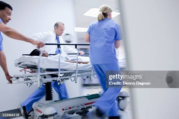 doctor and nurses pushing woman on gurney - beat the clock - fotografias e filmes do acervo