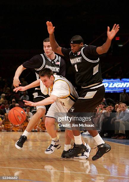 Mike Gansey the West Virginia Mountaineers gets sandwiched between DeSean White and Tuukka Kotti of the Providence Friars during the Big East Men's...