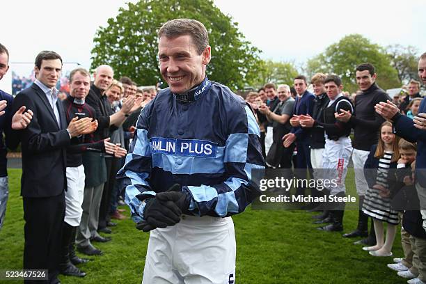 Richard Johnson champion jockey walks into the parade ring as fellow jockeys form a guard of honourat Sandown Park on April 23, 2016 in Esher,...