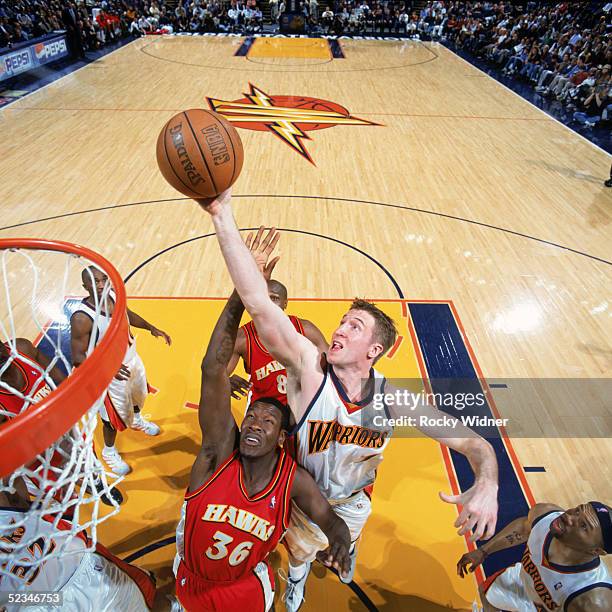 Troy Murphy of the Golden State Warriors rebounds against Royal Ivey of the Atlanta Hawks during the game at The Arena in Oakland on February 23,...