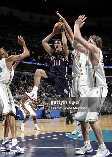 Zoran Planinic of the New Jersey Nets drives to the basket against Bostjan Nachbar and Chris Andersen of the New Orleans Hornets on March 9, 2005 at...
