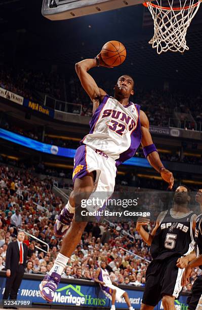 Amare Stoudemire of the Phoenix Suns dunks while Robert Horry the San Antonio Spurs watches on March 9, 2005 at America West Arena in Phoenix,...