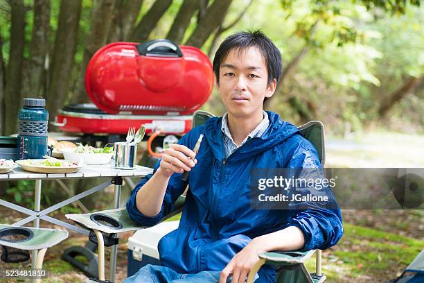 man smoking an electronic cigarette outdoors - bbq smoker stock pictures, royalty-free photos & images