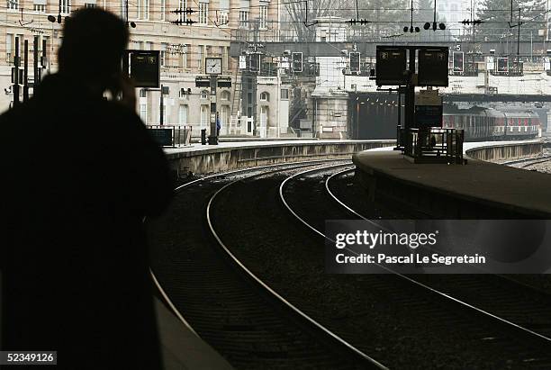 An unidentified commuter makes a phone call from the platform at Paris Saint Lazare railway station March 10, 2005 in Paris, France. All the main...