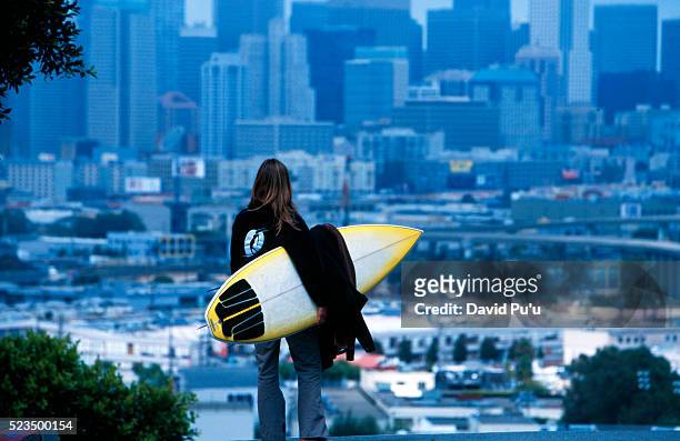 surfer looking toward city - city to surf stock pictures, royalty-free photos & images