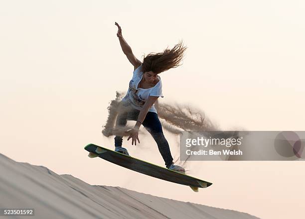 woman surfing over sand dunes, punta paloma, tarifa, costa de la luz, cadiz, andalusia, spain - stunt person foto e immagini stock
