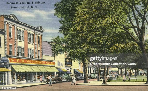 Hand colored postcard of corner of park, with people in street, cars parked in front of shops, FW Woolworth, Company, and Miles shoes, titled...