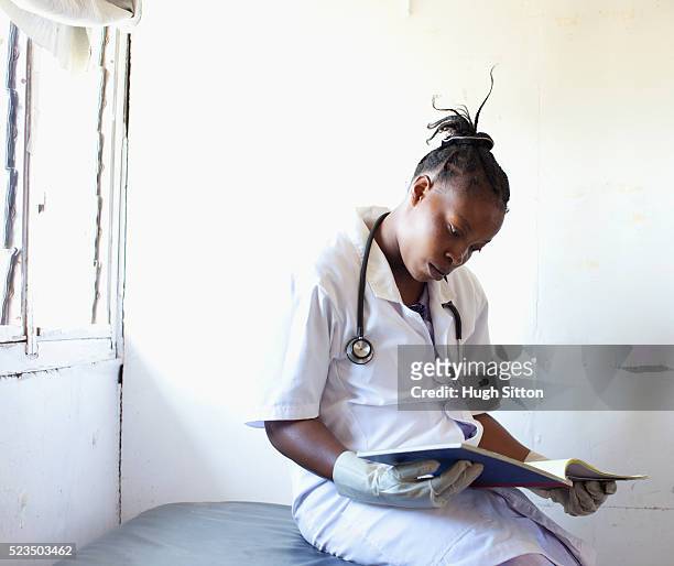 female doctor reading book - archival hospital stock pictures, royalty-free photos & images