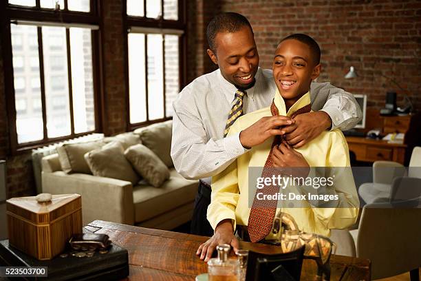 father helping son with necktie - adjusting necktie stockfoto's en -beelden