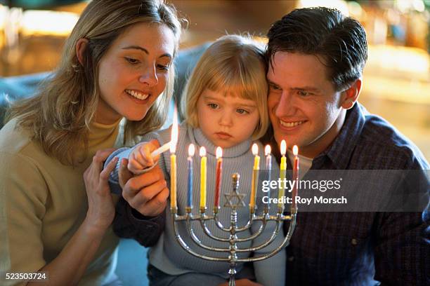 family lighting menorah - menorah photos et images de collection