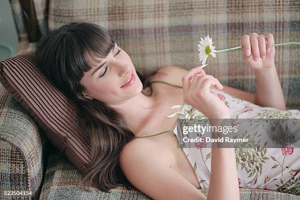 woman pulling petals from flower - effeuiller la marguerite photos et images de collection