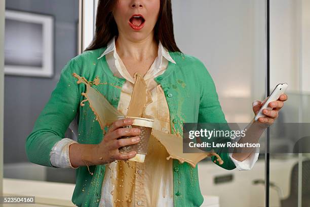 woman in office environment spilling coffee - kaffeefleck stock-fotos und bilder