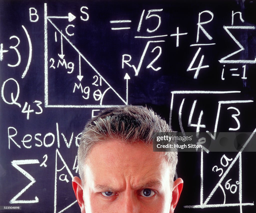 Man in front of a board with numbers
