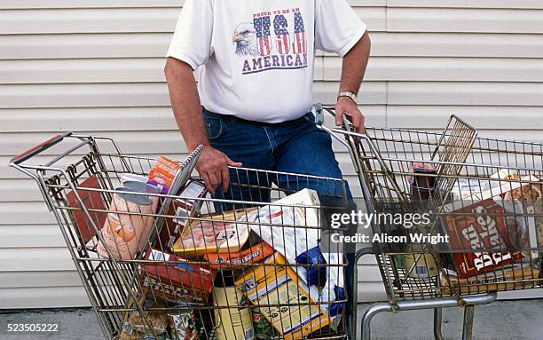 man at foodbank with carts filled with groceries - appalachia poverty stockfoto's en -beelden