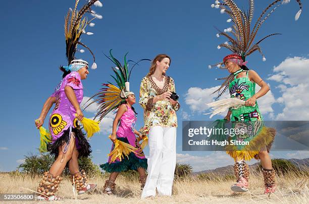 mexican aztec indians dancing around female tourist - astecas imagens e fotografias de stock