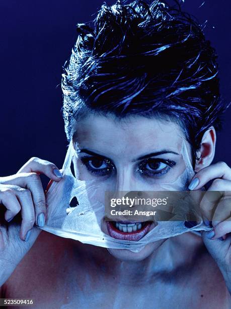 woman peeling off face mask - peel off mask stock-fotos und bilder