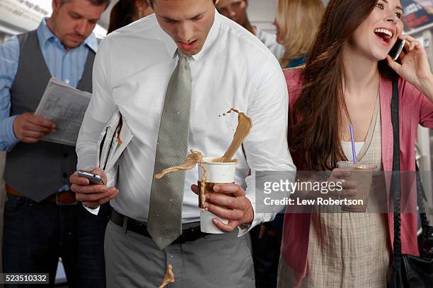 business man spilling coffee in crowded train - coffee spill fotografías e imágenes de stock