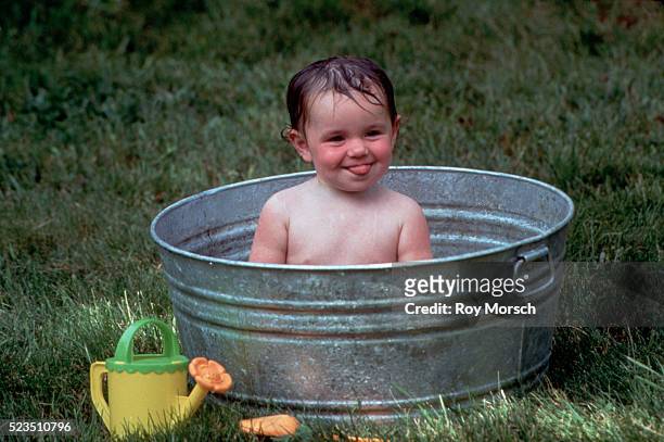 baby in washtub smiling - wash bowl stockfoto's en -beelden