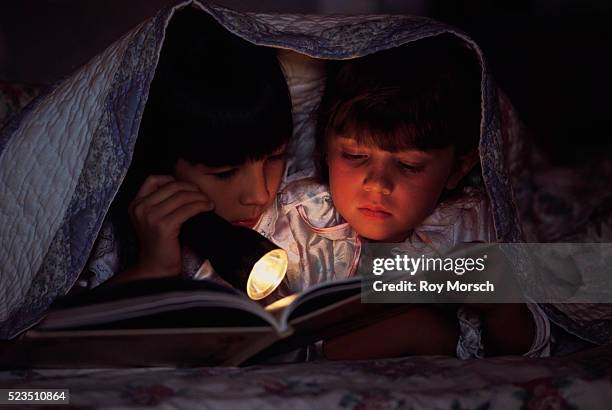 friends reading together in bed - bedtime story book stock pictures, royalty-free photos & images