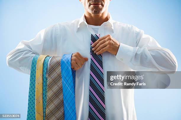 businessman selecting tie - choix photos et images de collection