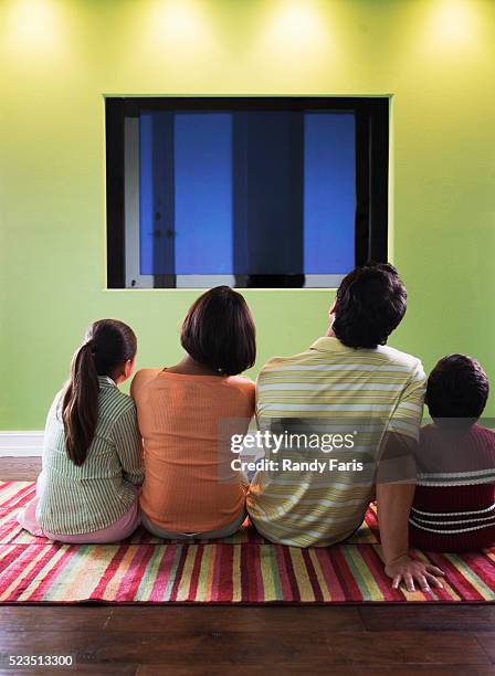 family watching television - family watching tv from behind stockfoto's en -beelden