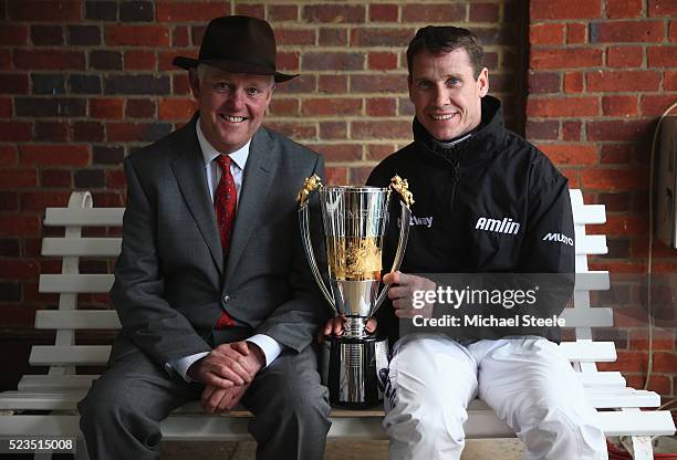 Richard Johnson the newly crowned champion jockey poses with the winners trophy alongside trainer Philip Hobbs at Sandown Park on April 23, 2016 in...