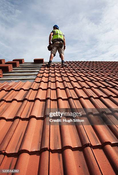 roofer working on construction site - roof tile stock-fotos und bilder