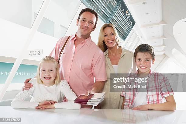 family with two children (10-12, 13-15) checking in at airport desk - portraits of people passport stock pictures, royalty-free photos & images