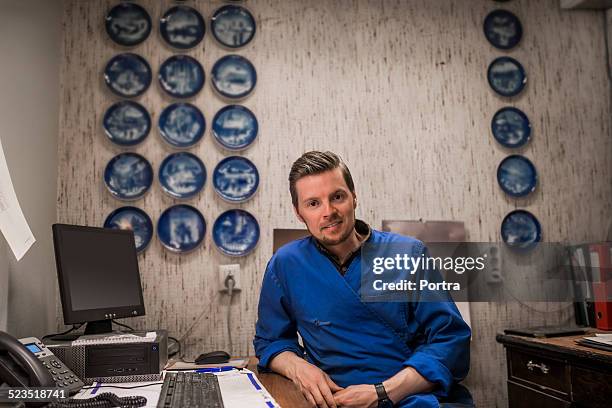 confident male worker sitting at computer desk - wall hanging stock pictures, royalty-free photos & images