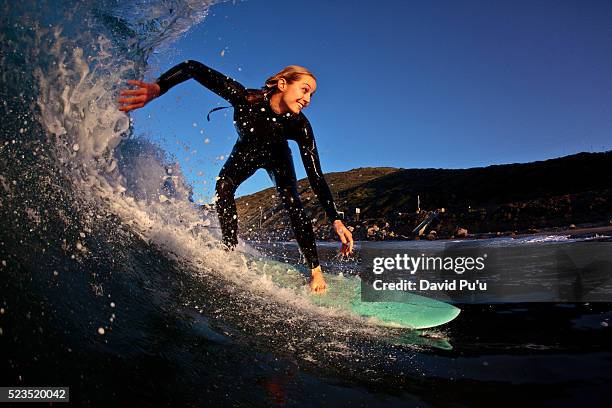 young woman surfing - surfer wetsuit stock pictures, royalty-free photos & images