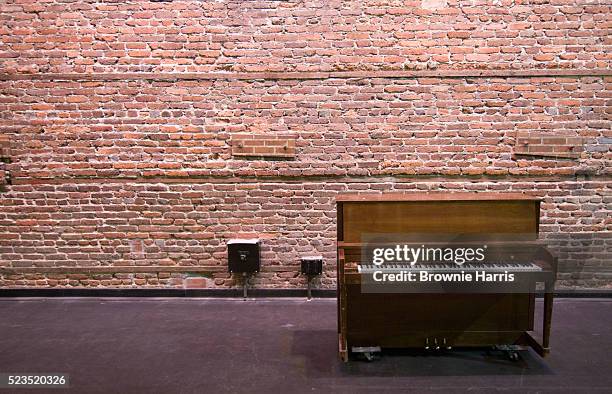 piano standing on backstage in theatre against brick wall - backstage stock pictures, royalty-free photos & images