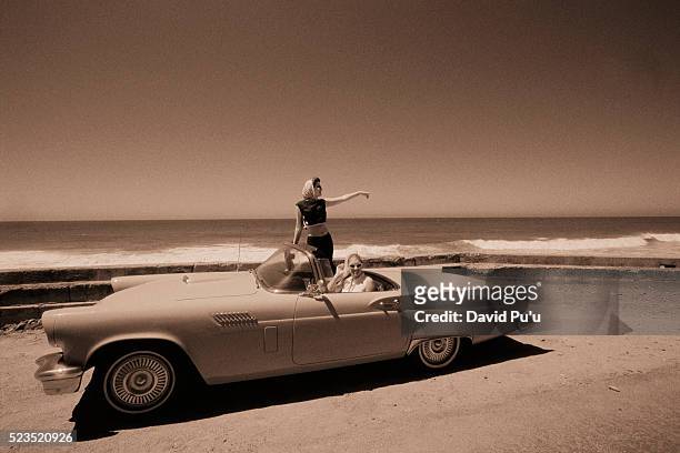 driving vintage car on beach - 50s car fotografías e imágenes de stock