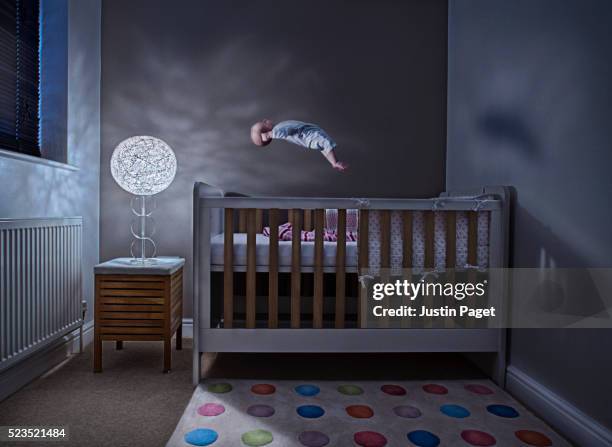 baby (1-6 months) levitating above cot in bedroom - bassine stock pictures, royalty-free photos & images