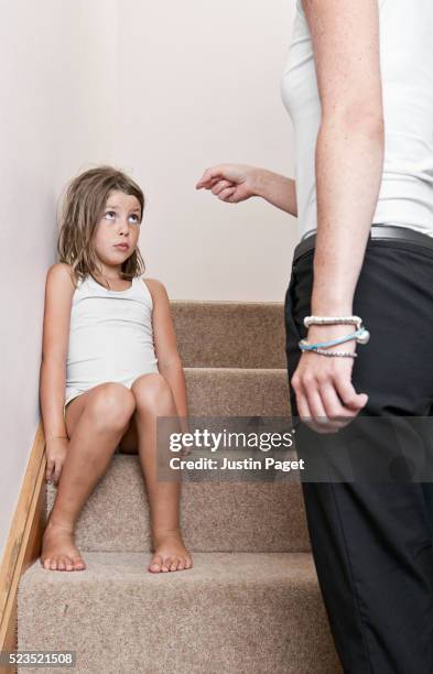 mother telling off daughter (7-9) - berispen stockfoto's en -beelden