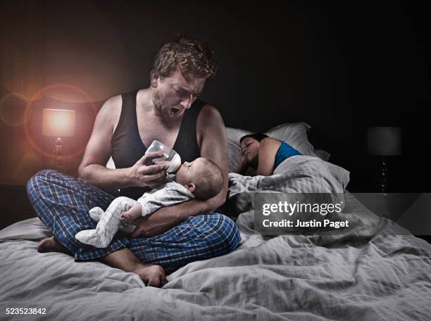 father bottle feeding infant (1-6 months)whilst mother sleeps - baby night stock-fotos und bilder