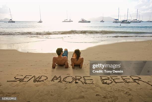 couple relaxing on beach - cane garden bay stock-fotos und bilder